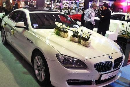 BMW 6 Series convertible decorated with white roses for weddings