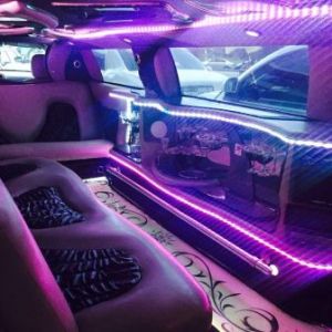 Limousine interior with special led lighting system and bar equipped with champagne glasses