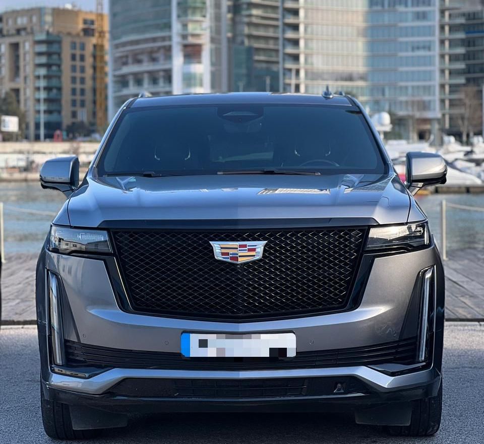 Cadillac Escalade 2023 Silver parked in front of large buildings of Beirut downtown area